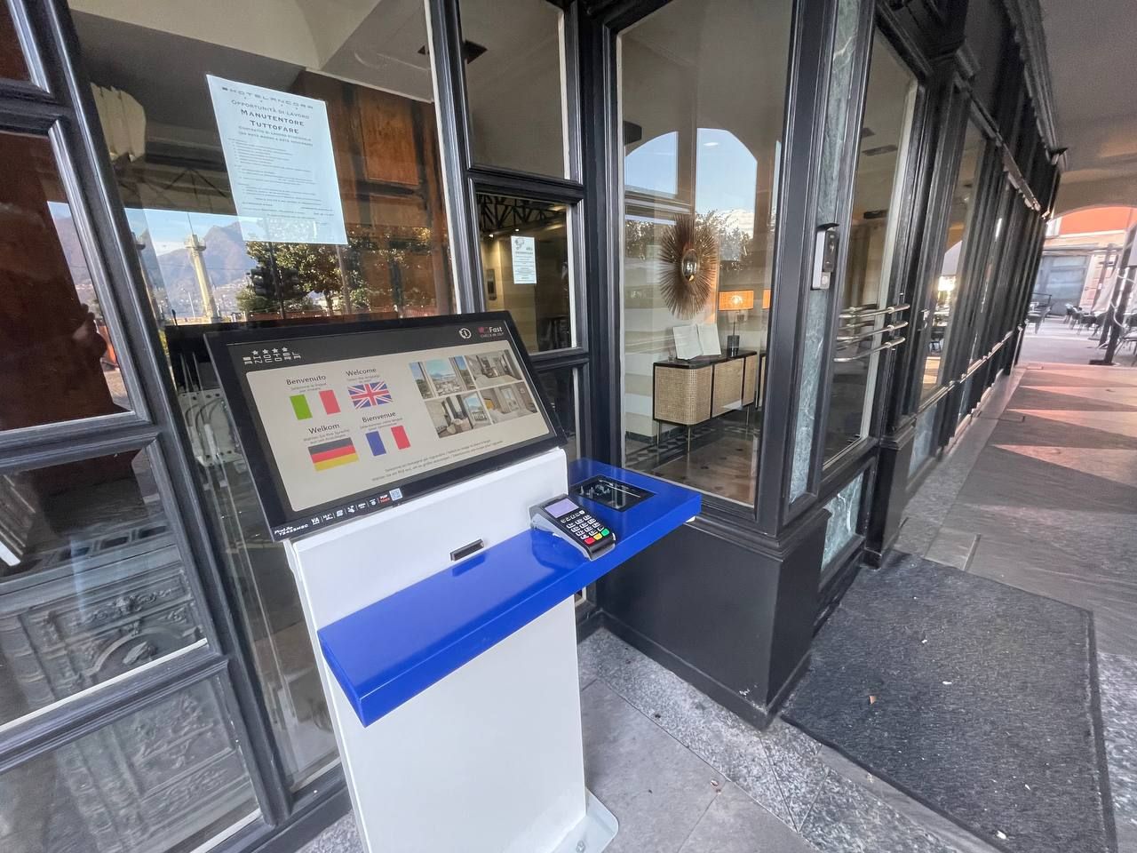 Il totem del check-in all'ingresso dell'Hotel Ancora, sotto i portici