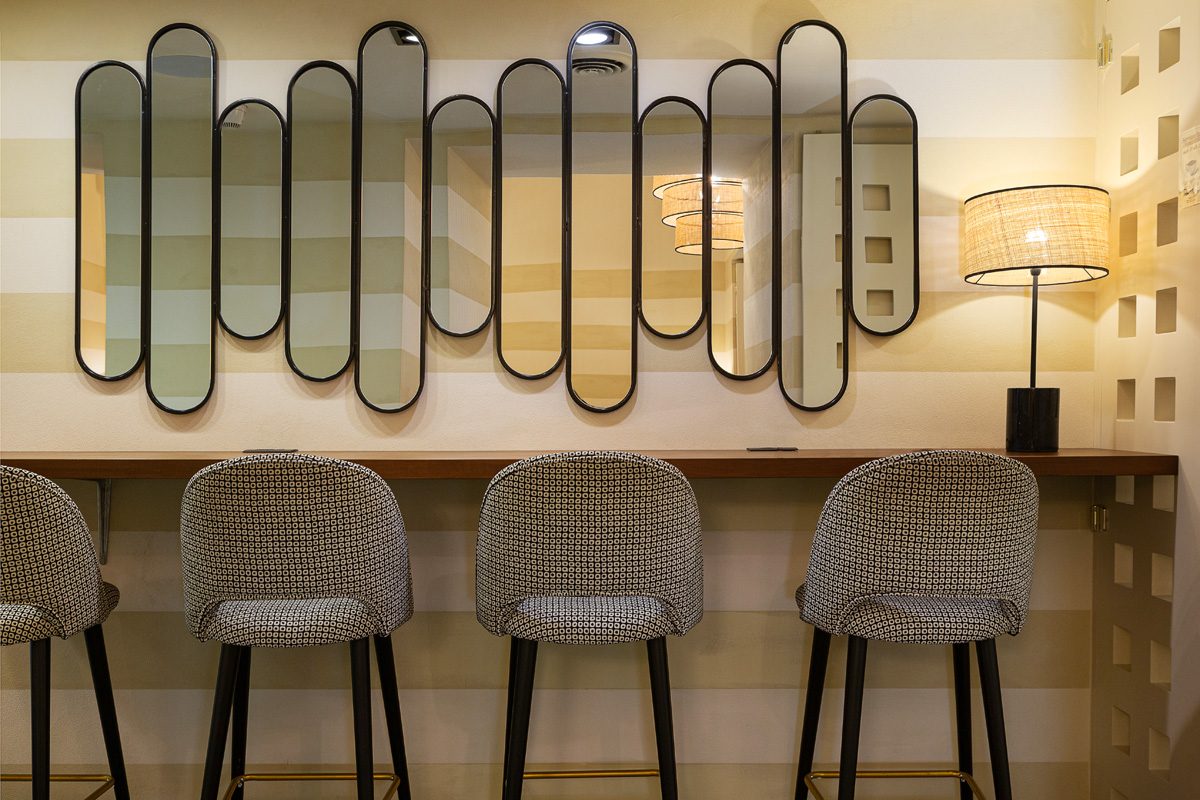 Il bancone con gli specchi e gli sgabelli
